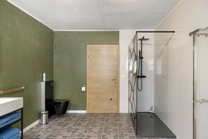 A bathroom with a shower, toilet, and sink.