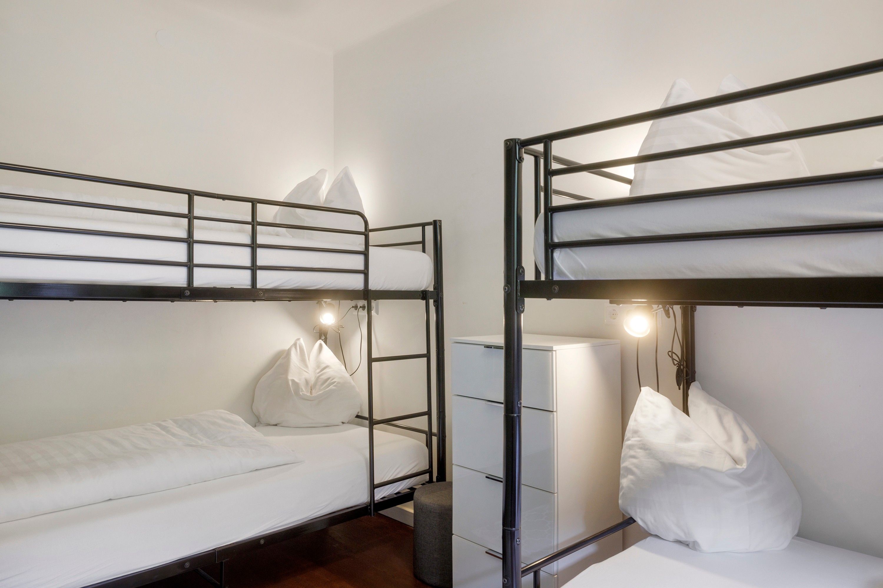 Habitación con literas, escritorio y lámpara.
