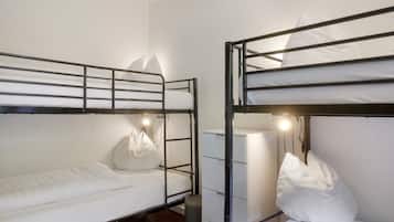 Habitación con literas, escritorio y lámpara.