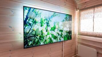 Un televisor montado en una pared de madera en una habitación con ventana y radiador.