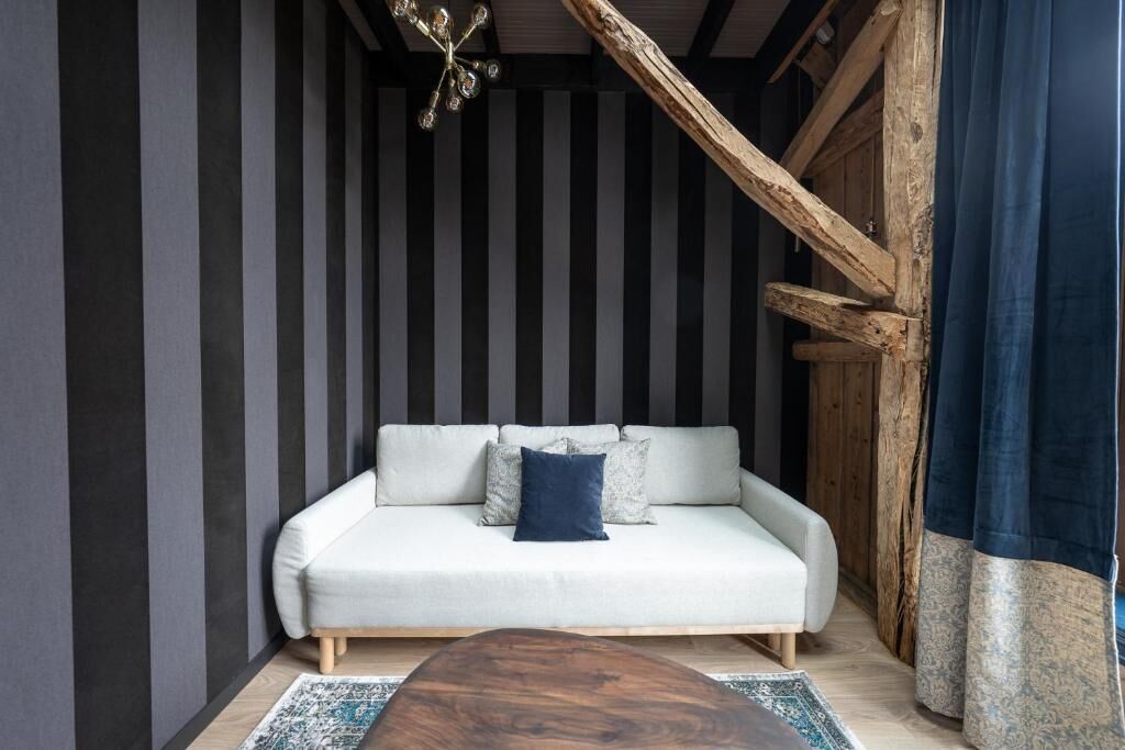 Une pièce comprenant un canapé, une table basse en bois et un tapis à motifs.