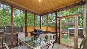 An enclosed patio with a glass table, chairs, and a grill. - Illini Dream House with Historic Retreat near UIUC and Downtown (Champaign)