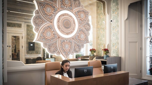 Una recepción con un muro decorativo, un área de estar y una computadora.