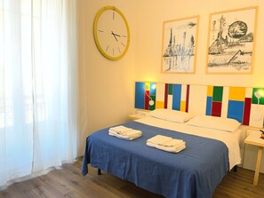 A hotel room with a bed, a wall clock, and two framed pictures. - Mafè Apt | Downtown & 5-Min Walk to the Station (Palermo)
