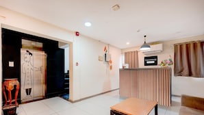 A reception area with a reception desk, a bench, a door with a cartoon character, and a sign that reads 'TOWNHOUSE.' - Classic With Balcony T Nagar Chennai (Chennai)