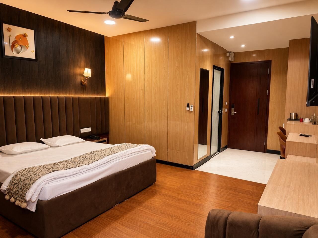 Camera d'albergo con un letto, comodino, lampada, armadio e un angolo cottura.