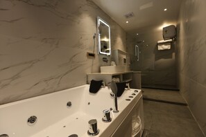 A modern bathroom with a large bathtub, a mirror with integrated lighting, a sink, and a shower area. - Cardinal Stay Kasauli Hills Glory (Dharampur)