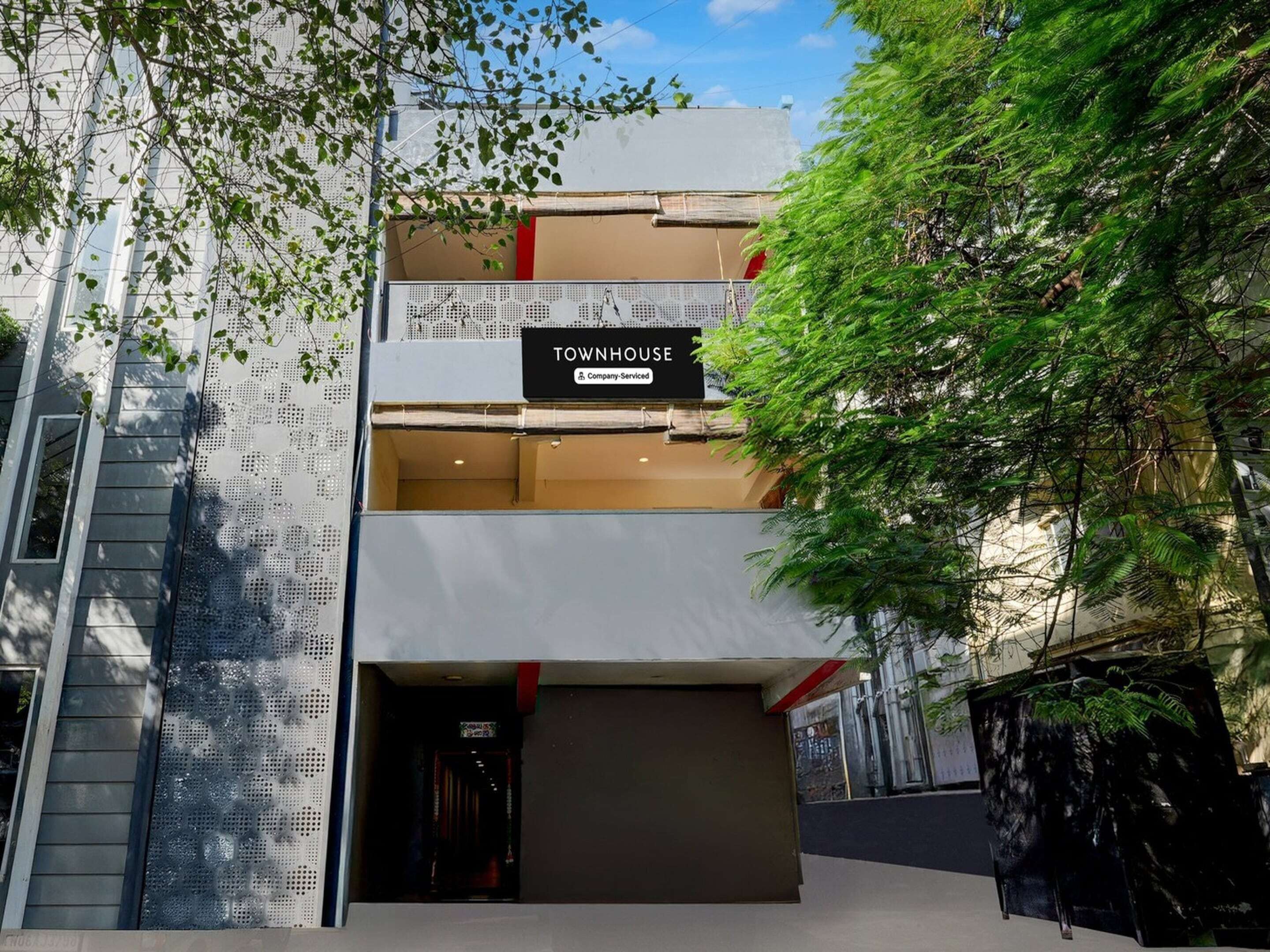 A modern building with a sign reading 'TOWNHOUSE Company Serviced.'