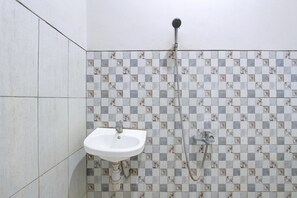 A bathroom with a sink, a shower, and patterned tiles. - Luxury Deluxe DBL Retreat W/ Free Wifi and Parking (Yogyakarta)