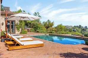 Zona de piscina con sillas de descanso y una pérgola.