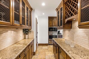 Una cocina con armarios de madera, encimeras de granito y electrodomésticos de acero inoxidable.
