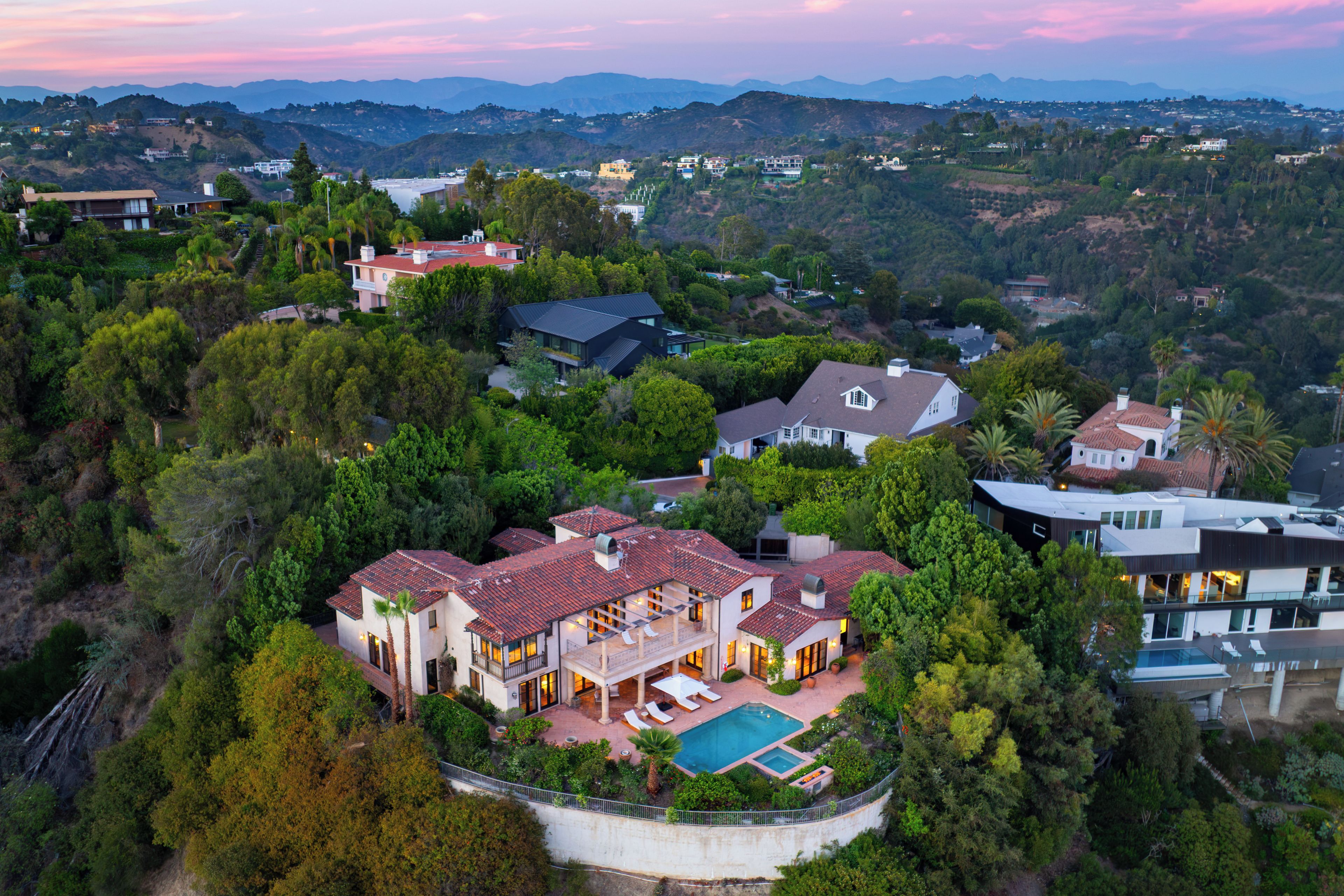 A large estate with multiple buildings, a swimming pool, and lush greenery.