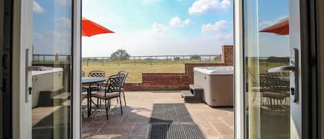 A patio area with outdoor seating and a hot tub.