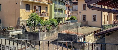 A courtyard with buildings, a metal fence, and a mountain backdrop.
