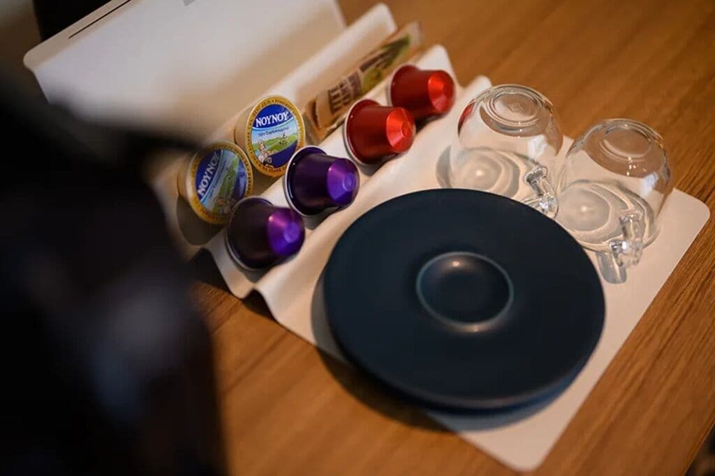 A table with a black plate, several colorful containers, and a white box.
