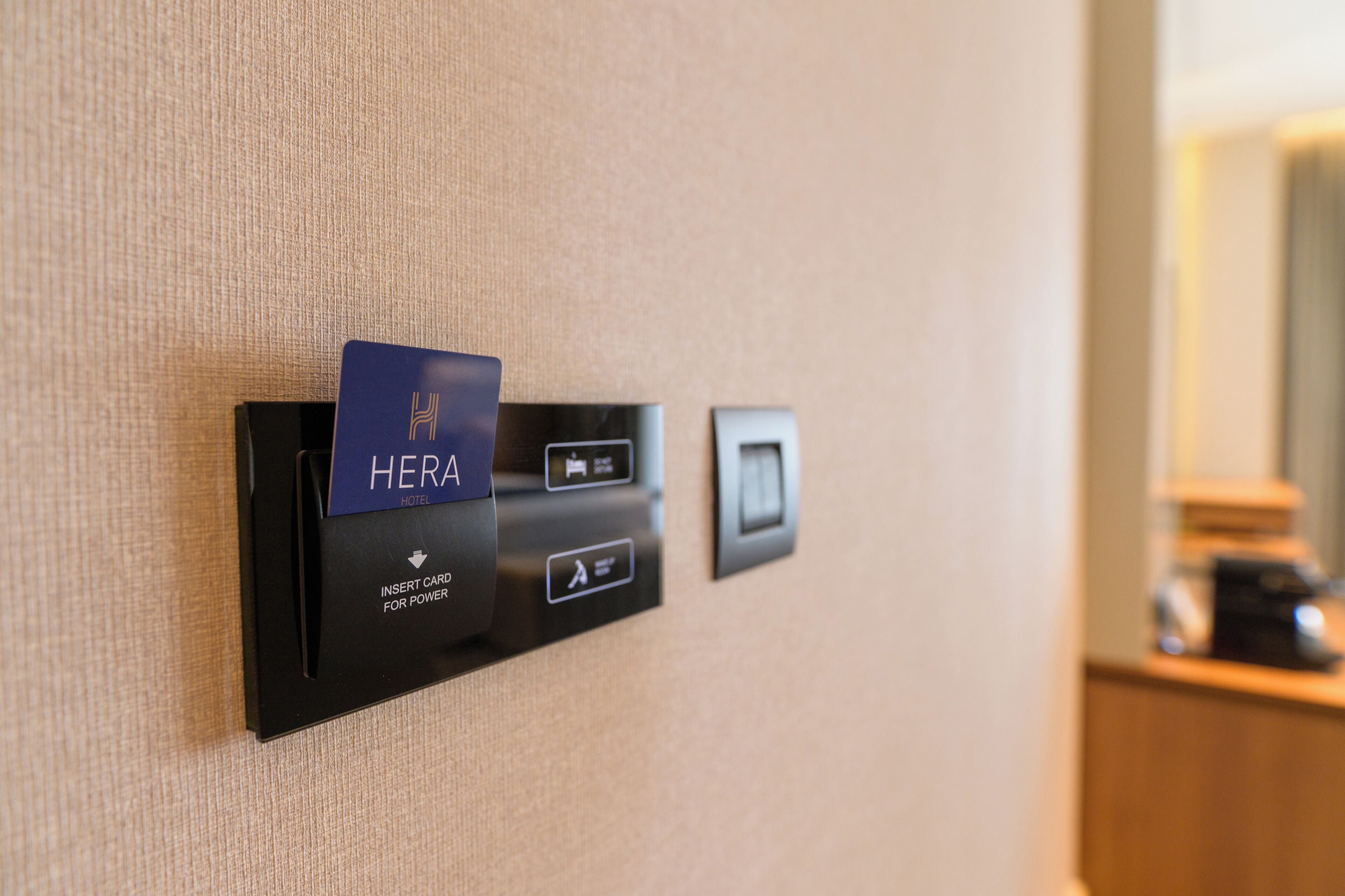 A card reader for a hotel named HERA, with a sign indicating 'INSERT CARD FOR POWER.'