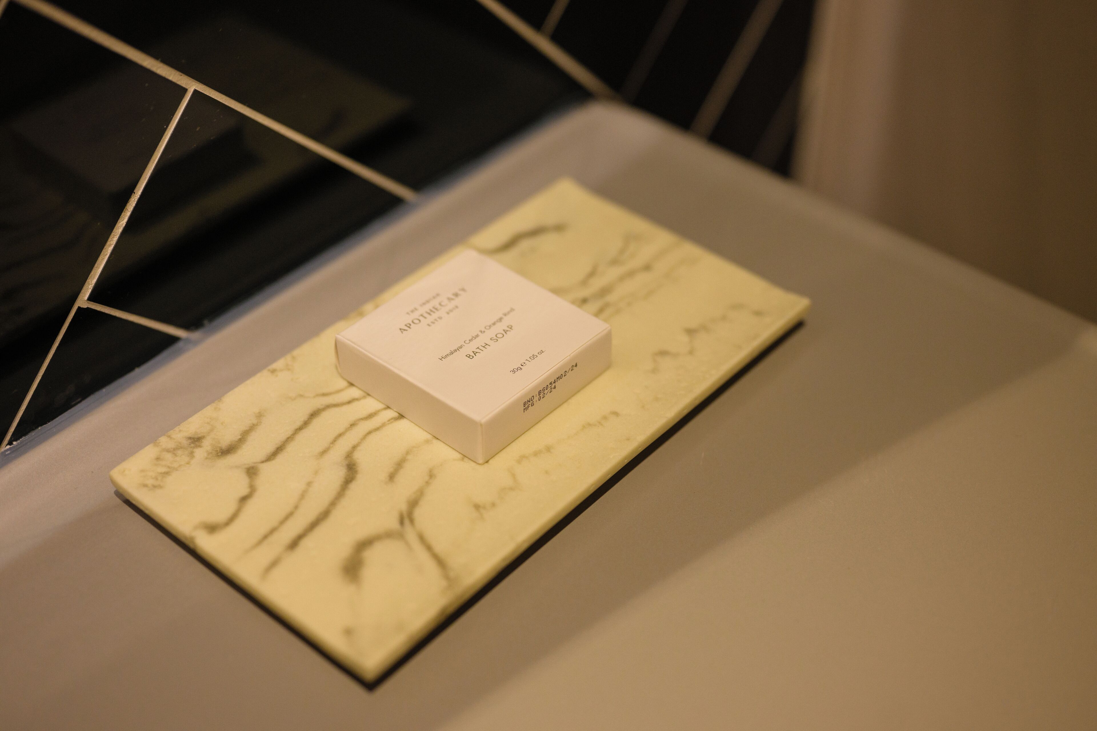A white box labeled 'APOTHECARY BATH SOAP' on a marble surface.