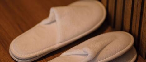 Une paire de pantoufles blanches sur un plancher en bois.