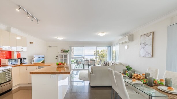 Une cuisine moderne avec un coin repas, un canapé et une vue sur la mer.