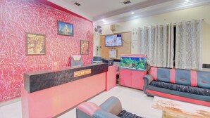 A reception area with a reception desk, a sofa, a television, and a fish tank.