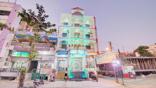 A multi-story building with a prominent hotel sign, a staircase leading to the entrance, and a visible ATM on the ground floor.