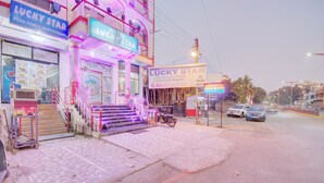 A hotel named 'Lucky Star' with a signboard, a staircase leading to the entrance, and a motorcycle parked outside.