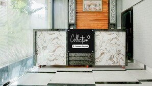 A reception desk with a 'Collection' sign, a framed picture above, and a checkered floor. - Deluxe Chahal Residency (Amritsar)