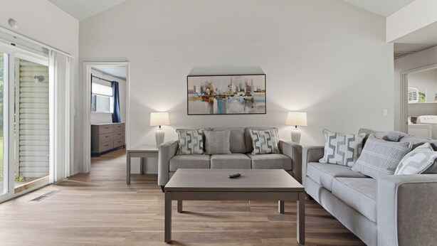 A living room with a sofa, a coffee table, and a painting on the wall.