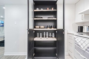 A kitchen with a built-in cabinet, a coffee maker, and a flat-screen TV. - Bright Basement Suite w Parking Near Mclennan Park (Kitchener)