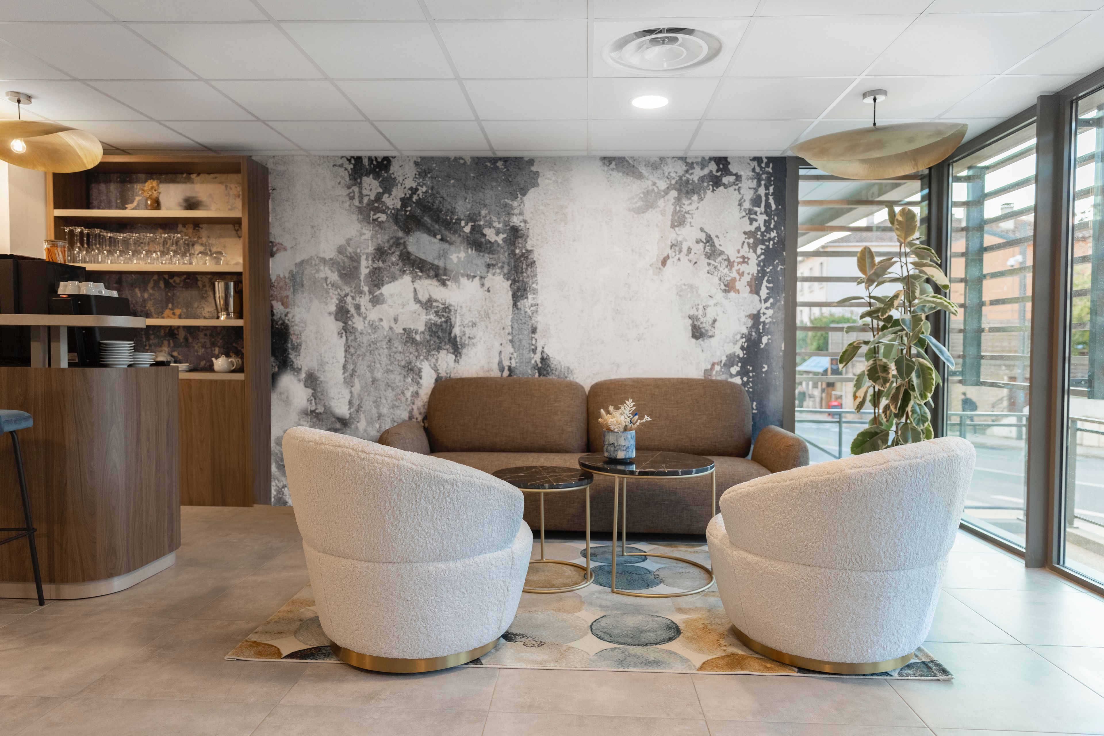 Un salón moderno con un sofá, dos sillones, una mesita de centro y una zona de bar con estanterías.