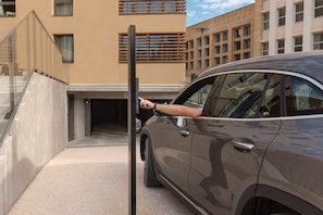 A car parked in a modern building with a glass entrance and a visible elevator. - Ibis Styles Aix-En-Provence Université (Aix-en-Provence)