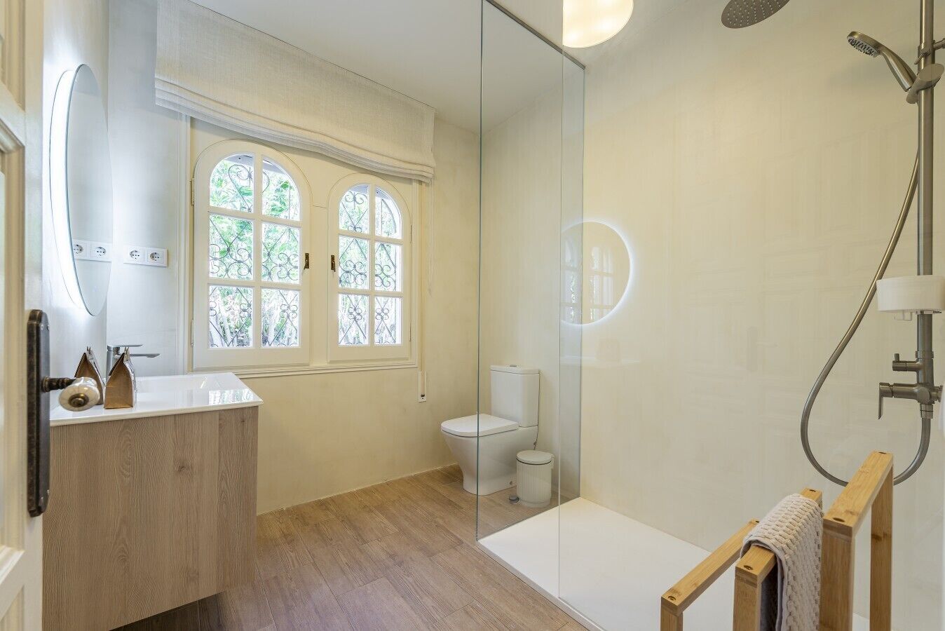 Een badkamer met een douche, toilet en wastafel met spiegel.