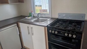 A compact kitchen with a sink, stove, and oven.