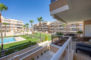 A residential building with multiple balconies, a swimming pool, and a well-maintained lawn. - Casa BiBo – Comfort & Relax on the Costa Blanca (Orihuela Costa)