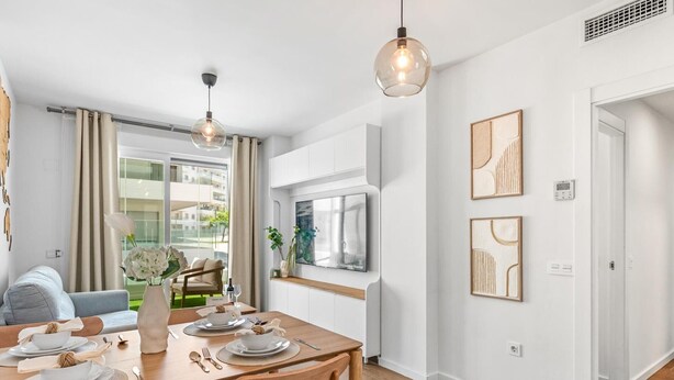 A modern kitchen with wooden flooring, a dining table set for four, and pendant lighting. - Exclusive apartment near Puerto Banús - 4 guests (Marbella)