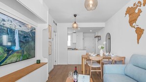 A modern living room with a flat-screen TV, wooden furniture, a dining area, and a world map on the wall. - Exclusive apartment near Puerto Banús - 4 guests (Marbella)
