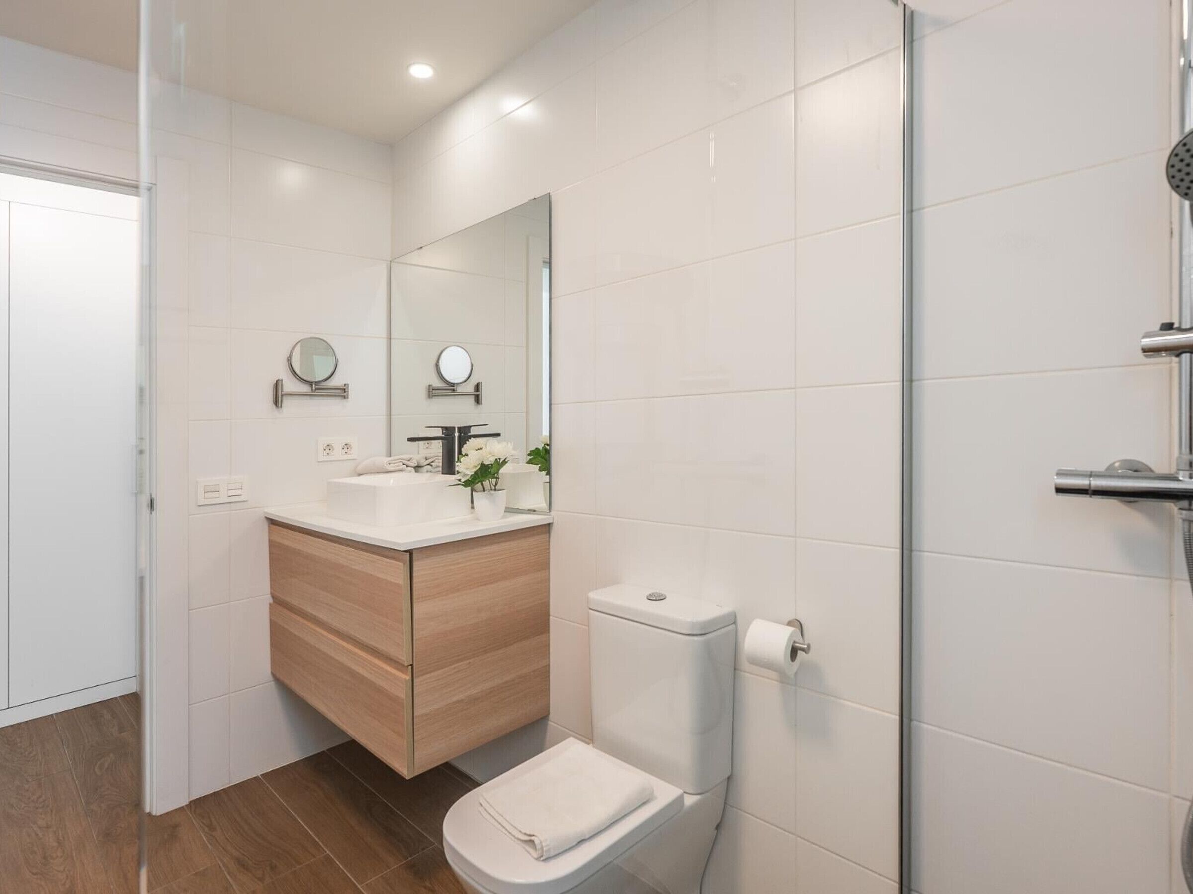 Une salle de bain moderne avec des toilettes, un lavabo et un miroir.