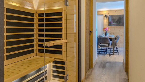 Een sauna met houten latten, een bank en een deur.