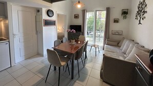 En moderne opholdsstue med spiseplads, sofa og fjernsyn.