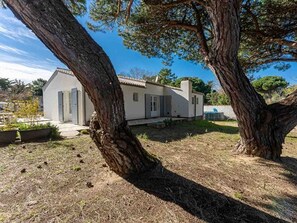 Una casa con facciata bianca, tetto in tegole e un garage ben visibile.