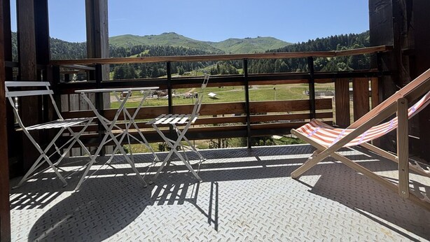 Ein Balkon mit Blick auf eine grüne Landschaft und Hügel.