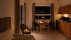 Um quarto com cama, mesa de cabeceira e janela com cortinas.