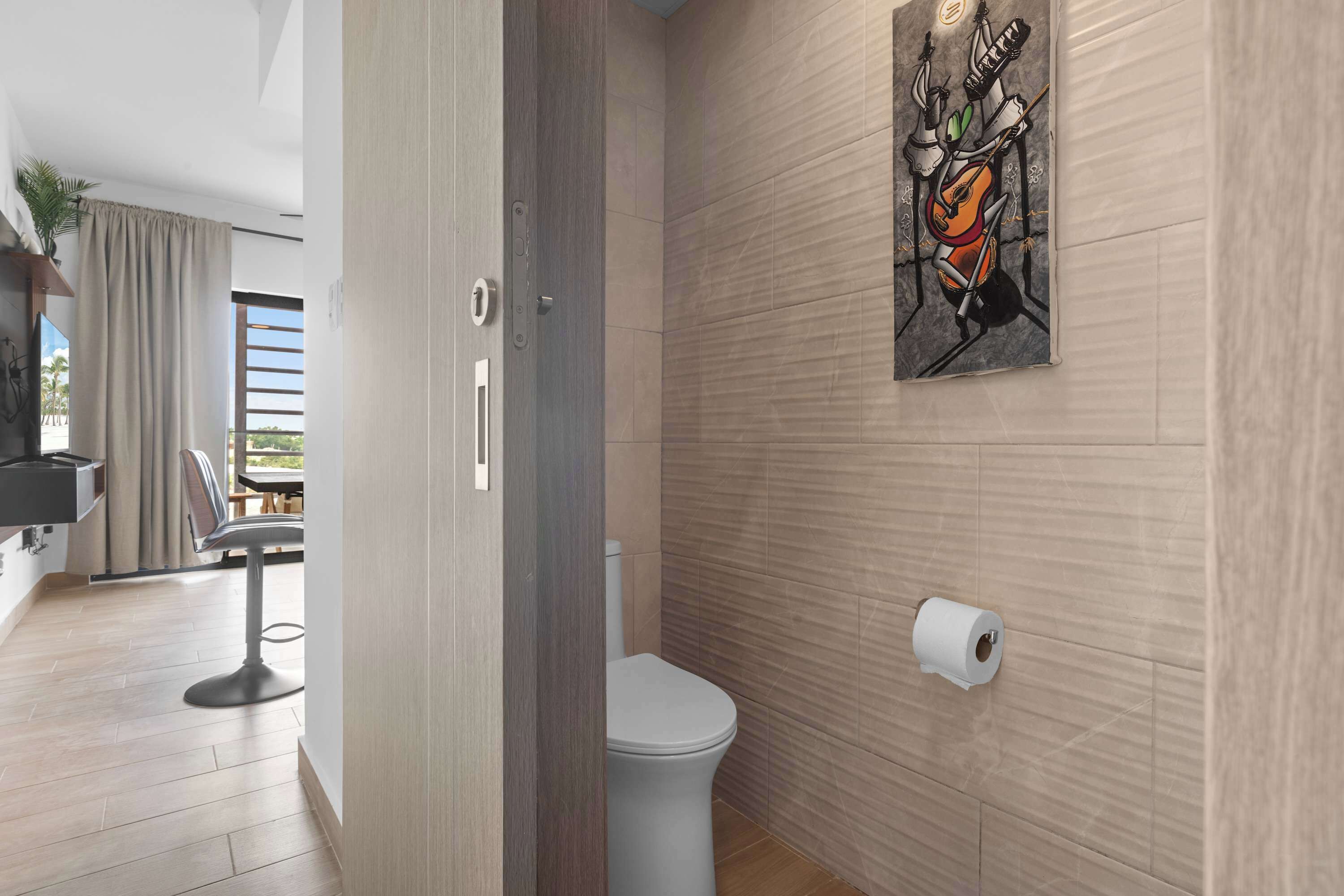 A modern bathroom with a toilet, a towel rack, and a wall-mounted toilet paper holder.