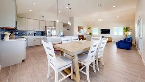 A spacious kitchen with white cabinets, a wooden dining table, and chairs. - PP189, Private Pool, Pet Friendly, Beautiful Sunsets (Port Aransas)