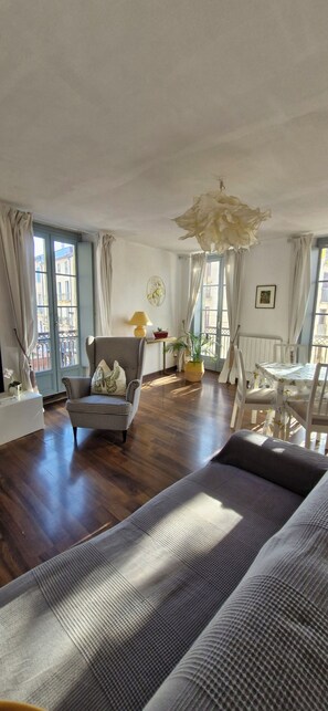 Una camera con un letto grande, una sedia, un tavolo e una lampada a sospensione.