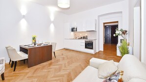 Eine moderne Küche mit weißen Schränken, einer zentralen Kochinsel und einem Essbereich mit einem langen Tisch und Stühlen.