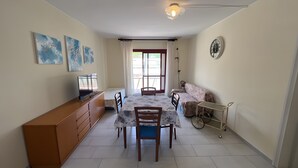Un espai habitable compacte amb zona de menjador, petita cuina i un seient petit.
