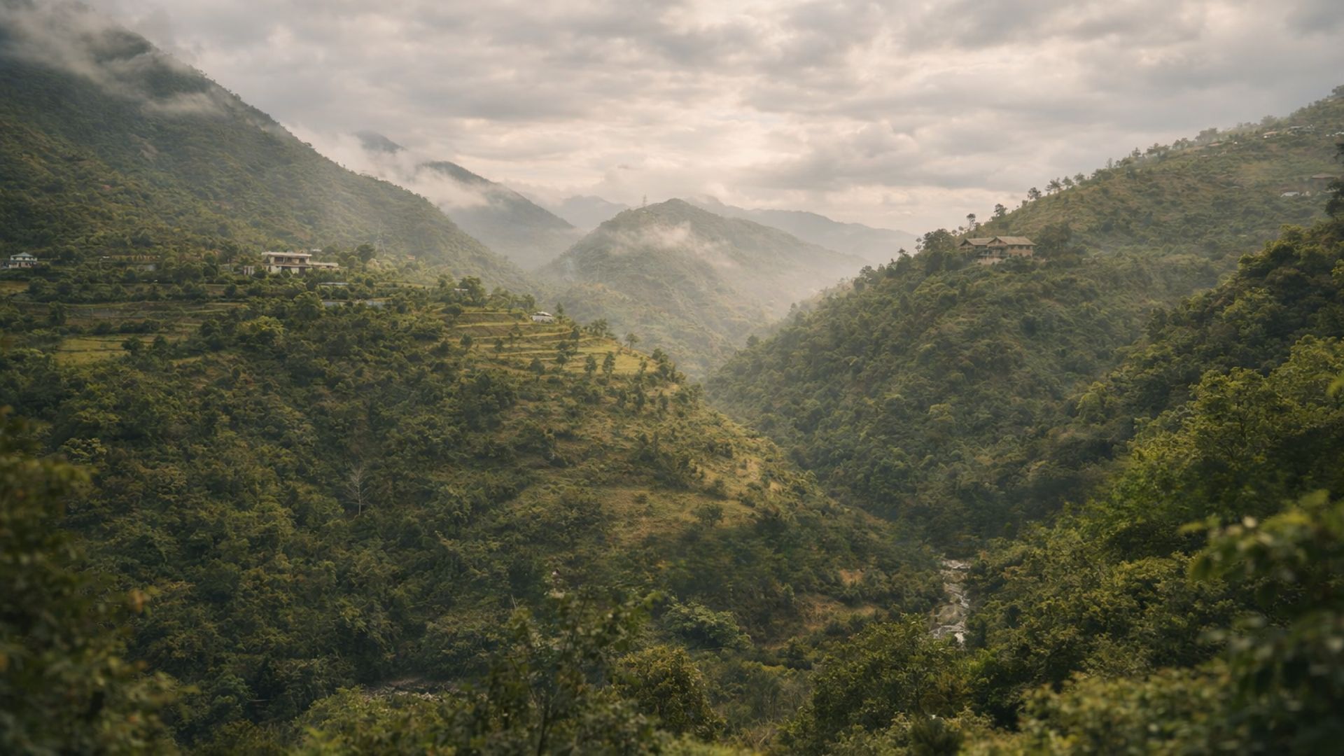 A mountainous landscape with terraced fields and a few buildings.