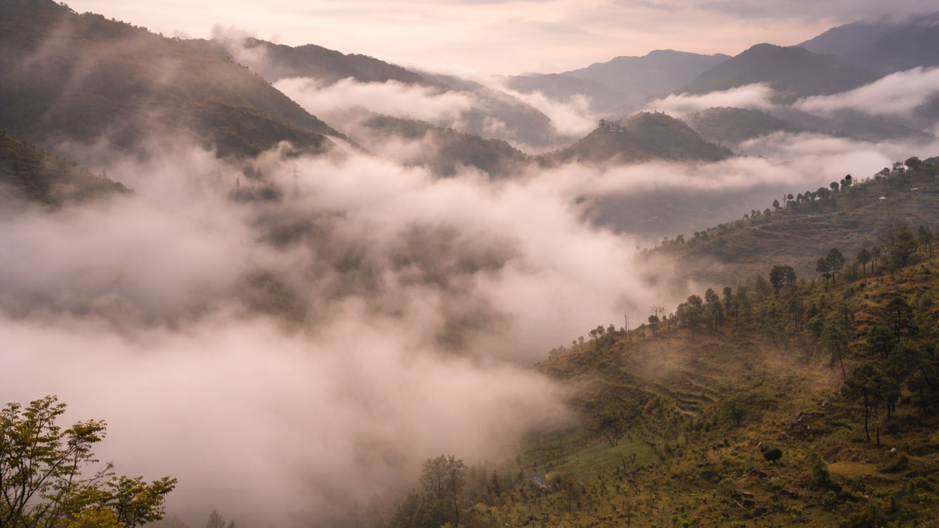 A mountainous landscape with dense fog covering the valleys.