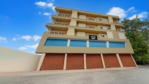 A multi-story hotel with a flat facade, balconies, and a sign indicating it is a hotel. - Deluxe Olive Residency (Kottayam)